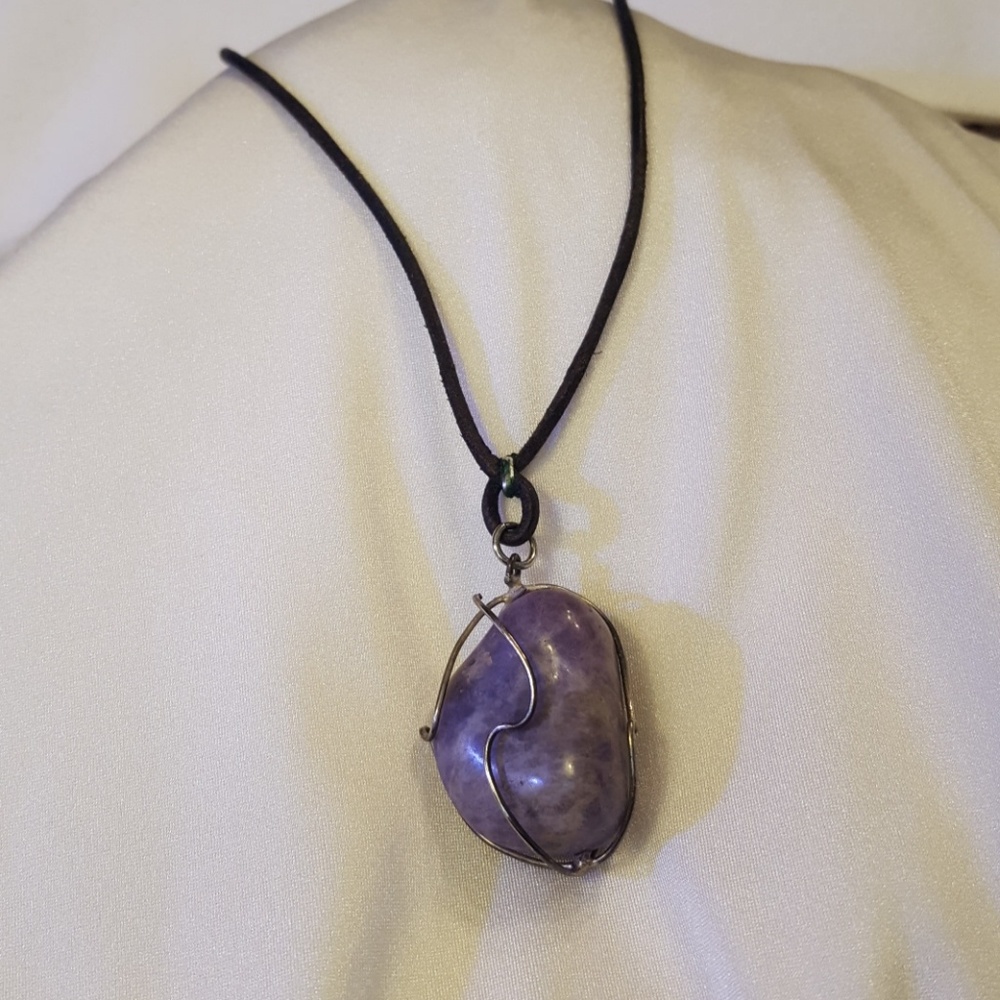 A large purple stone encased in artistic silver wi